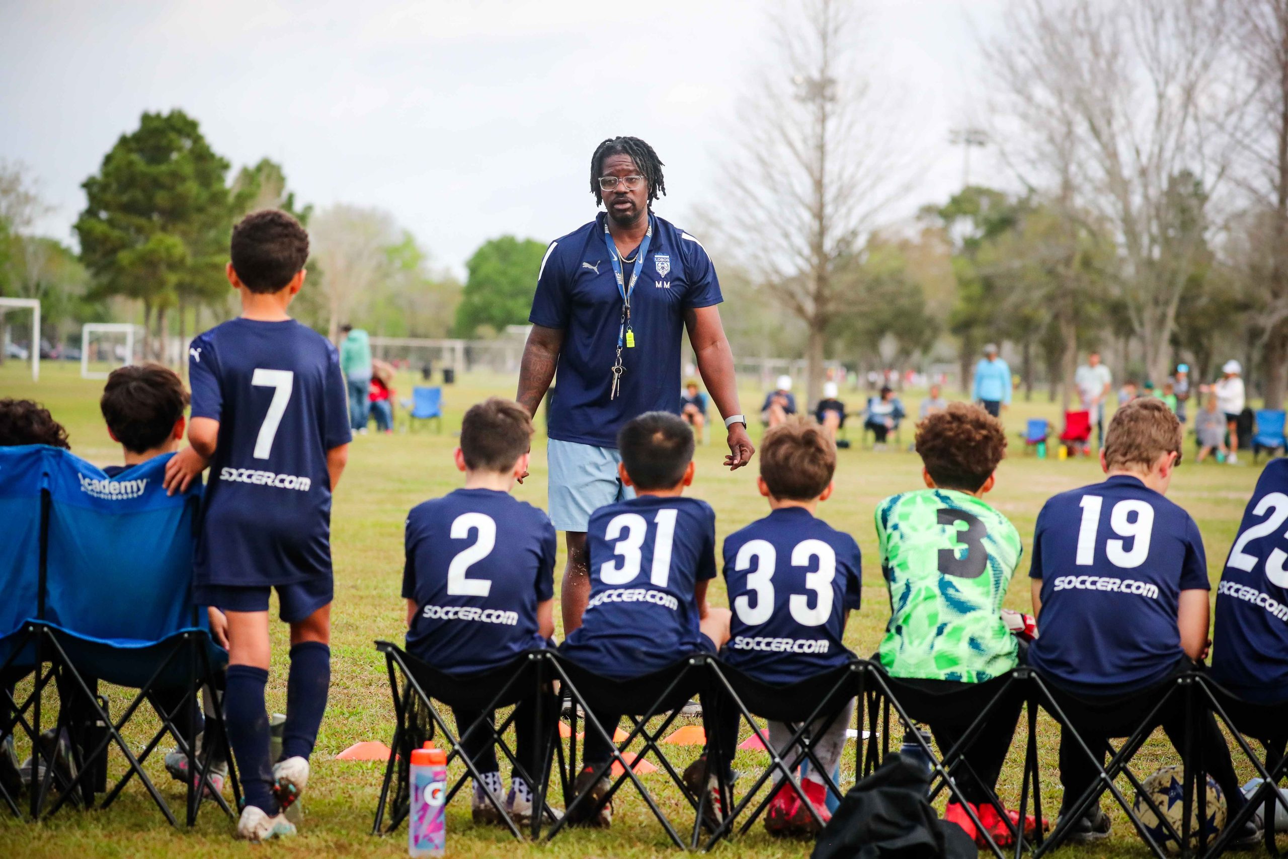 Coach Mira speaking with team